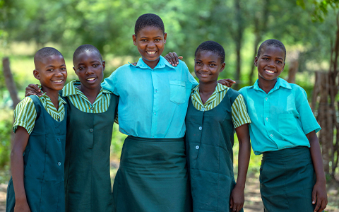 Promo image showing a group of smiling girls hopeful for their future