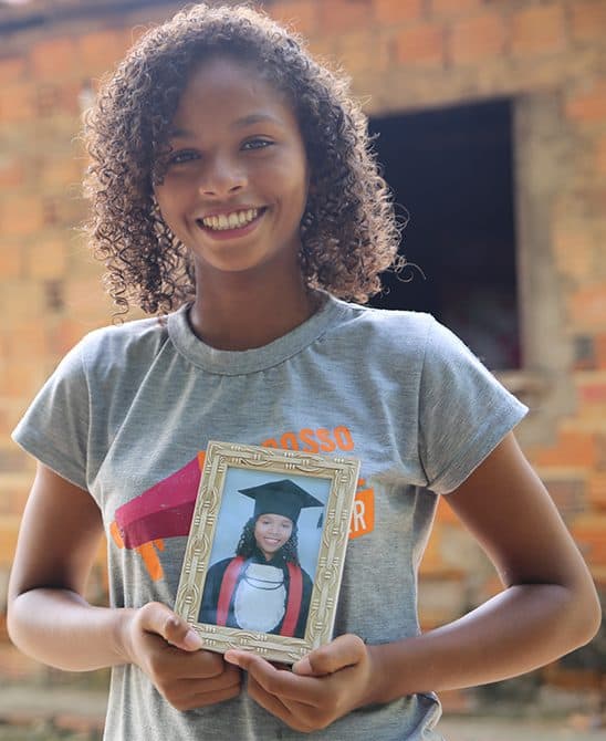 Sponsored Child in Brazil Holding Her Graduation Picture