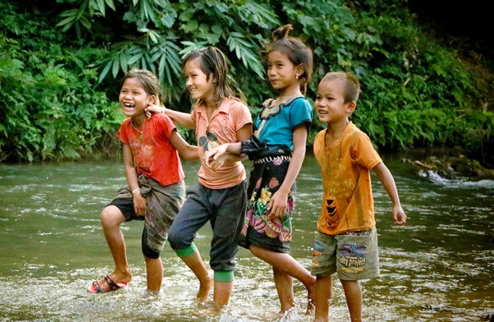 Children play in a stream in Laos