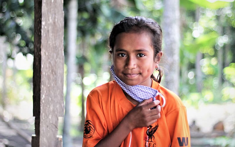 Girls like this one, removing her COVID mask, are protected from COVID-19 and other pandemics with masks and PPE