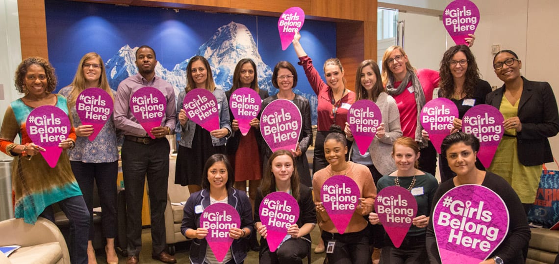 Katherine and other YAB members hold signs reading #GirlsBelongHere for International Day of the Girl