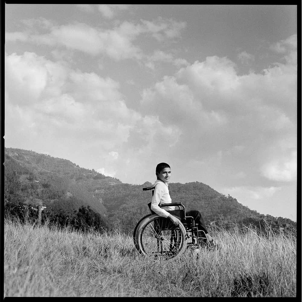 Anish uses a wheelchair, pictured here in a field
