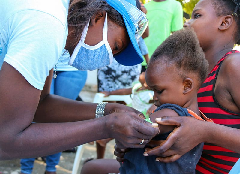 A young girl in Haiti is screened for malnutrition through a Plan program.