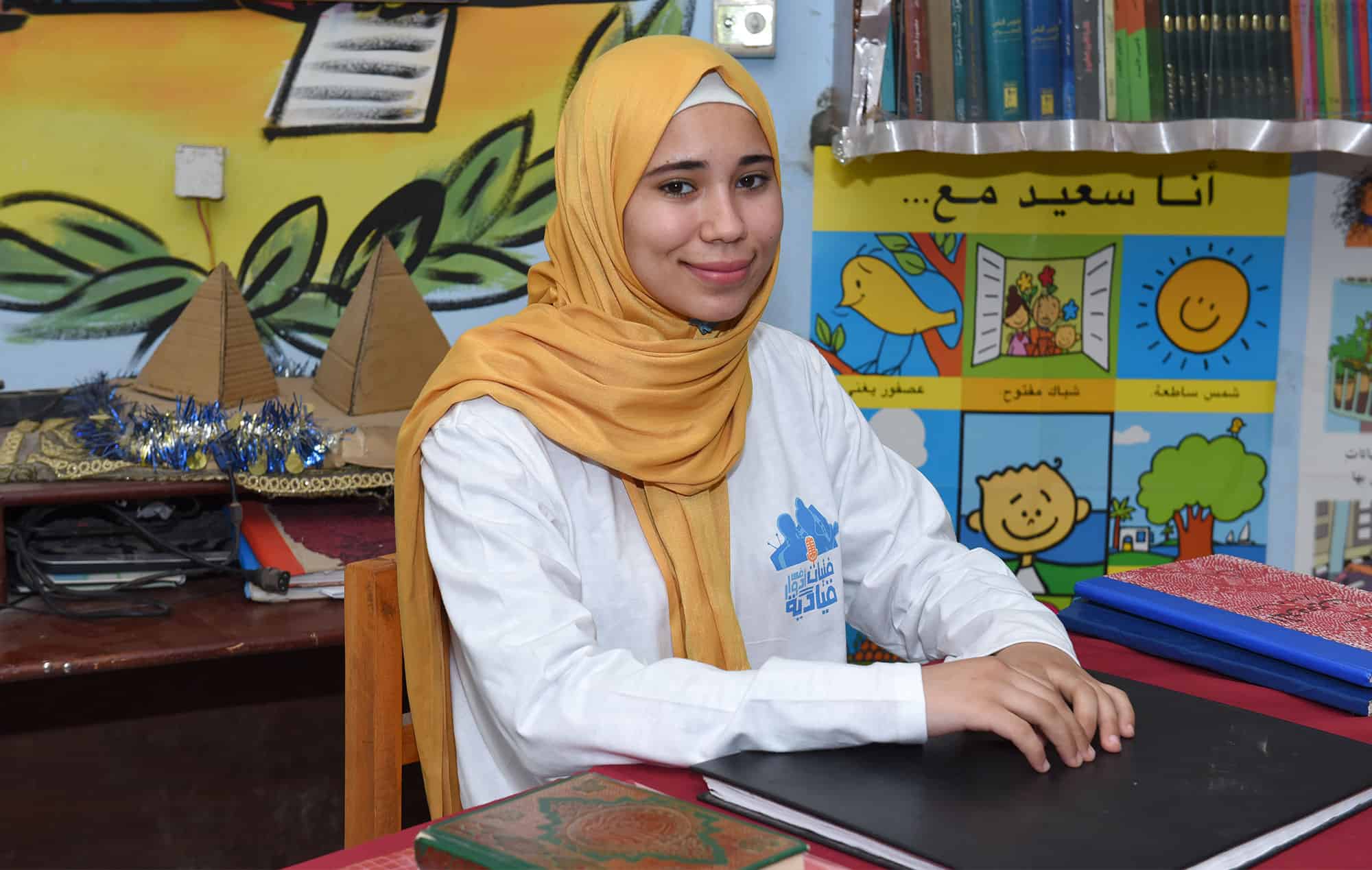 Shamaa, a girl in Egypt, sits at her desk dreaming of leading an awareness initiative about the danger of female genital mutilation
