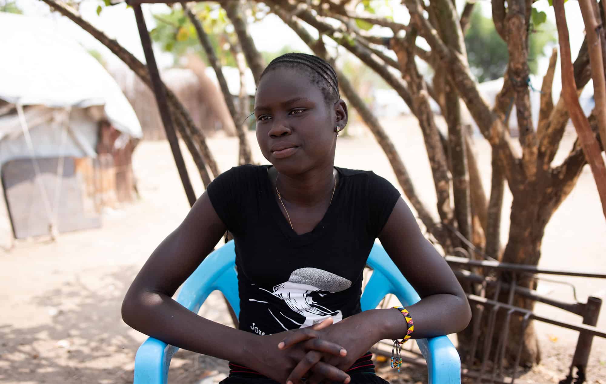 Martha, a girl in South Sudan, sits thinking about her desire to be a student instead of a forced child bride