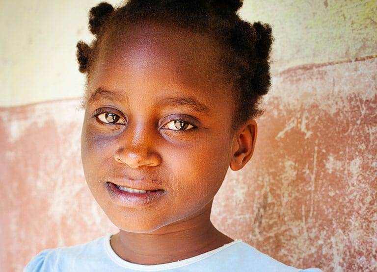 Young girl with bantu knots smiles mildly