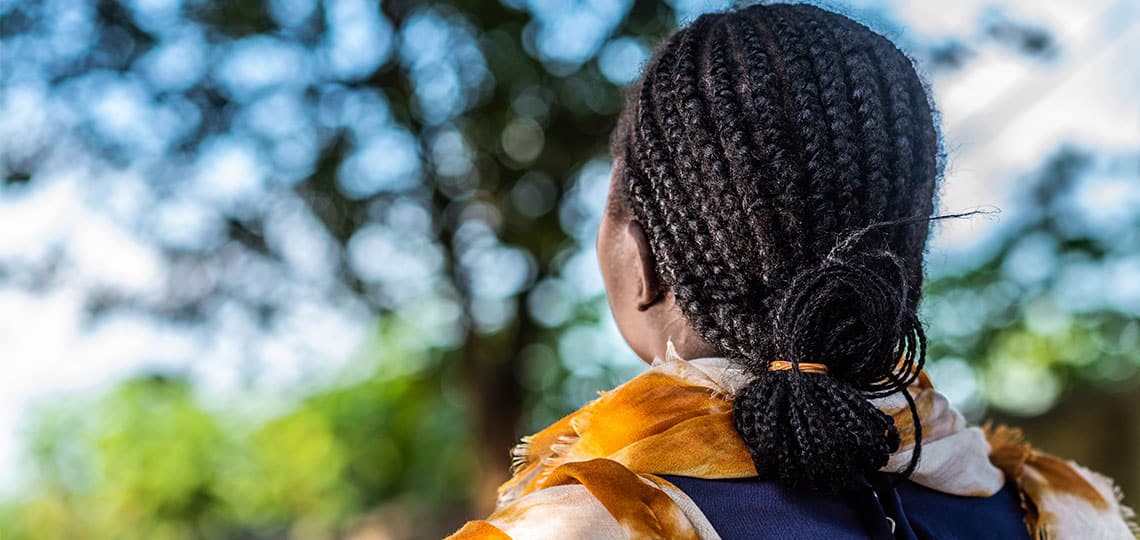 Woman with braids looks off to the distance