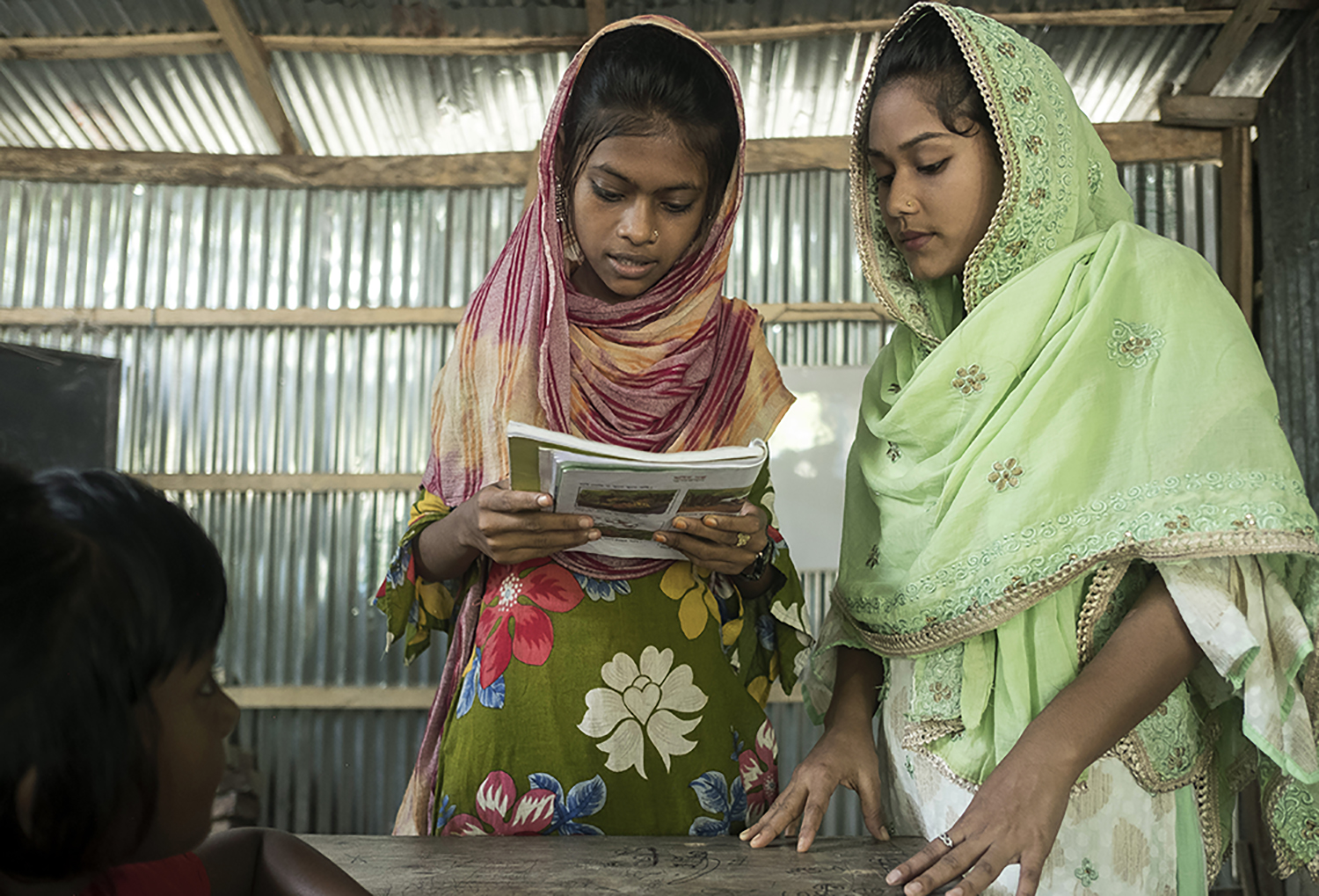 Tanzila helps one of her students with a reading assignment. 
