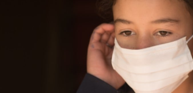 Latina girl in white COVID mask on black background