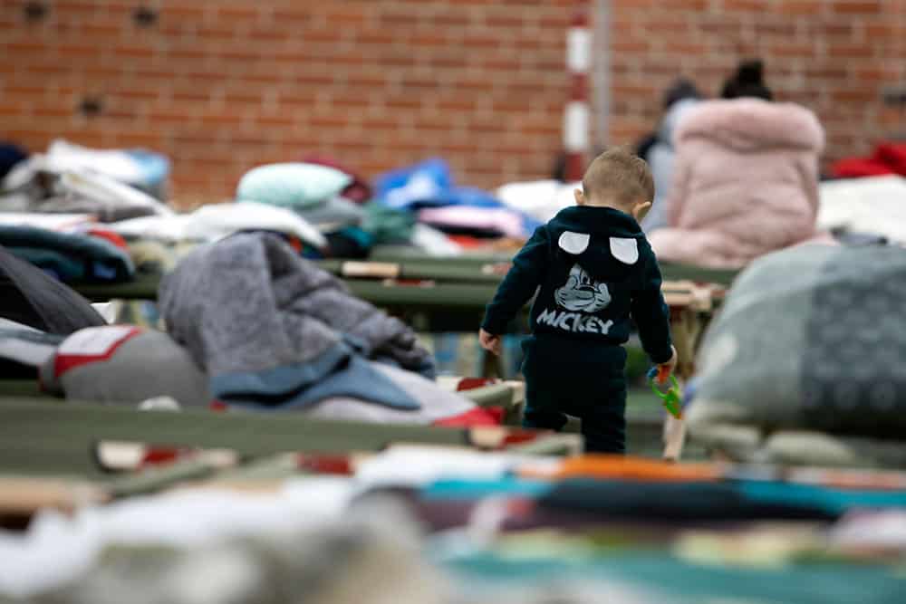 A young Ukrainian boy in a crowded refugee center in Poland.