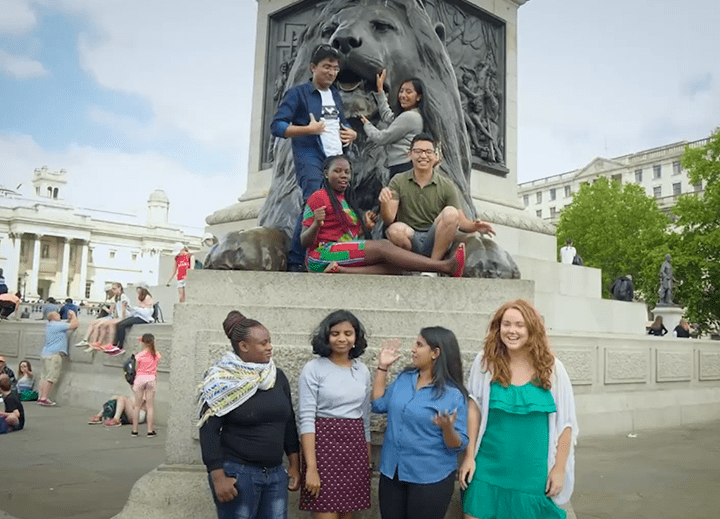 young people enjoying themselves in front of a statue of a lion