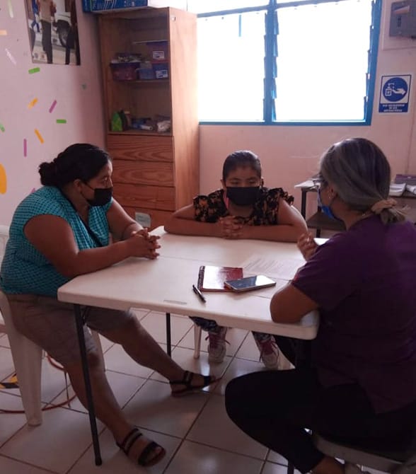 Three people sitting around a table.