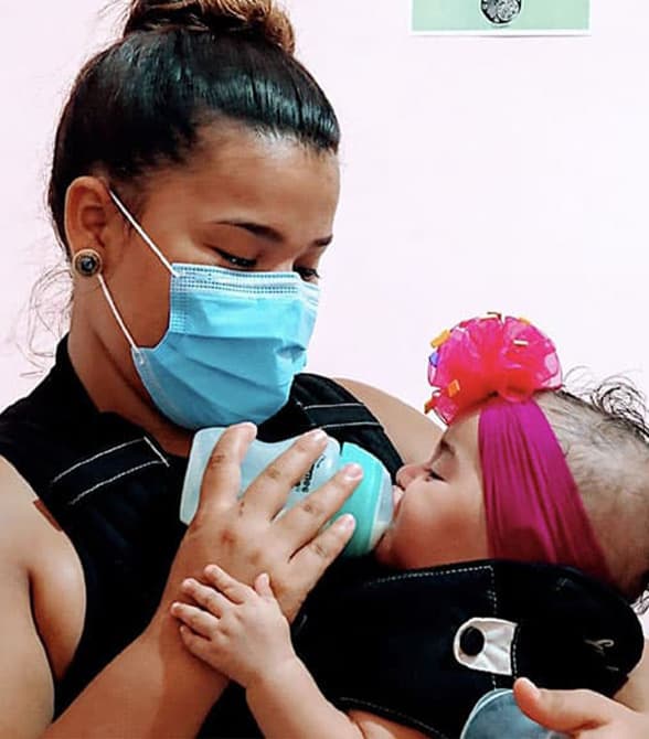 Young woman feeding a baby with a bottle.