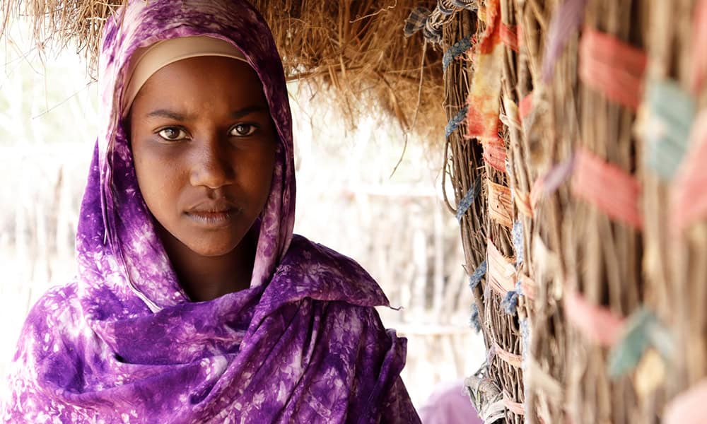 Nasra, age 12, walks more than 14 miles in a day to collect water. 