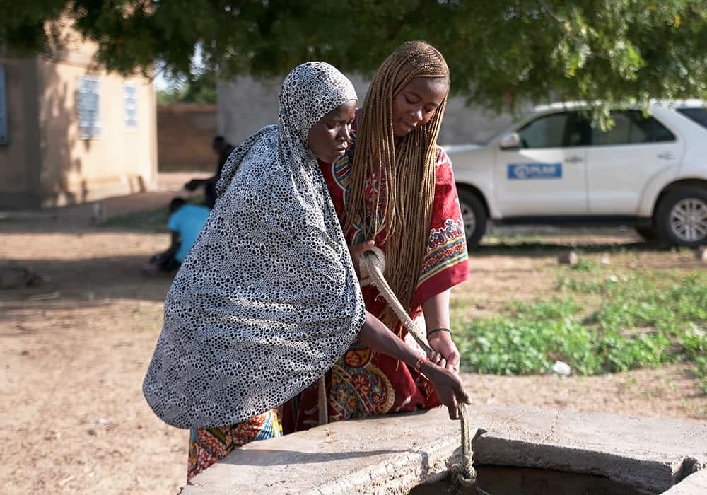 Floriane helps a woman named Tinnin draw water from the well. 