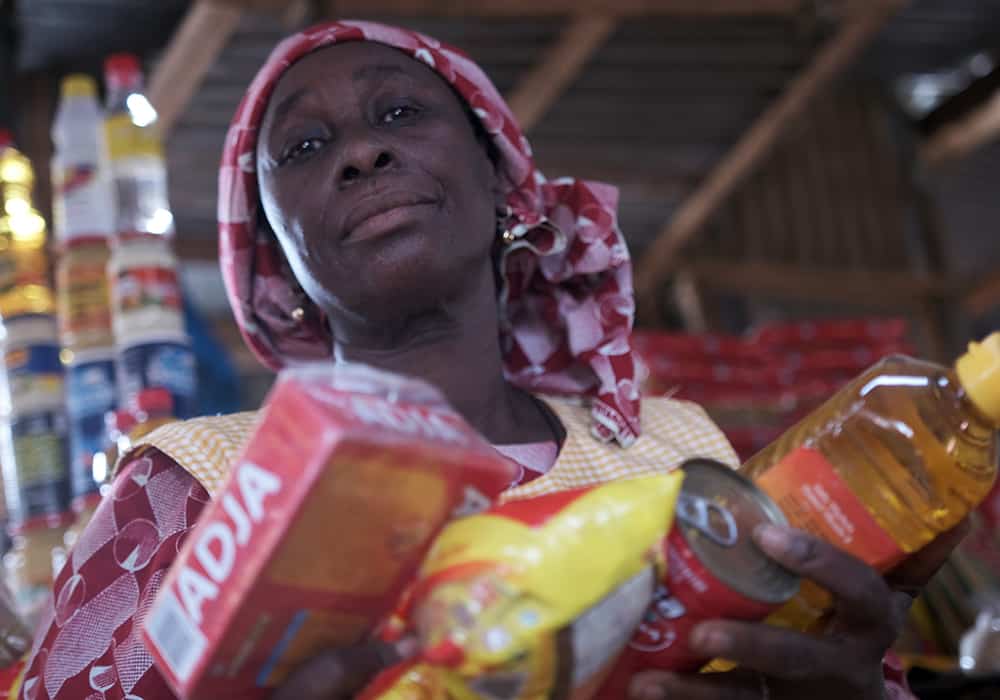 A displaced woman receives a food package from young leaders in Koupela. 