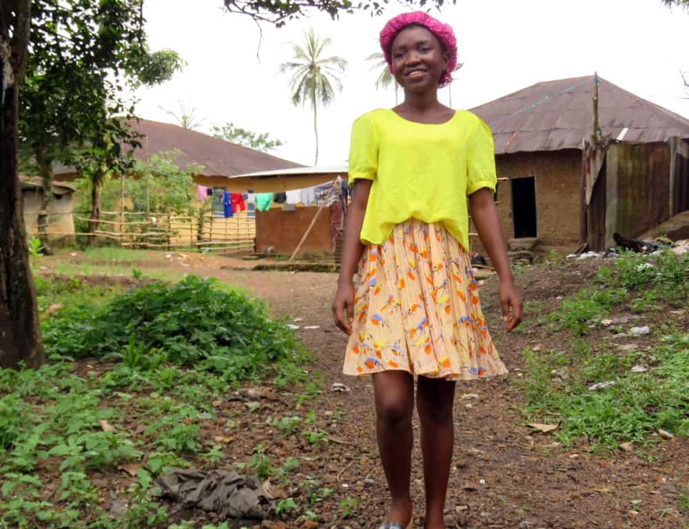 Fatmata walks along a path that leads to her home.