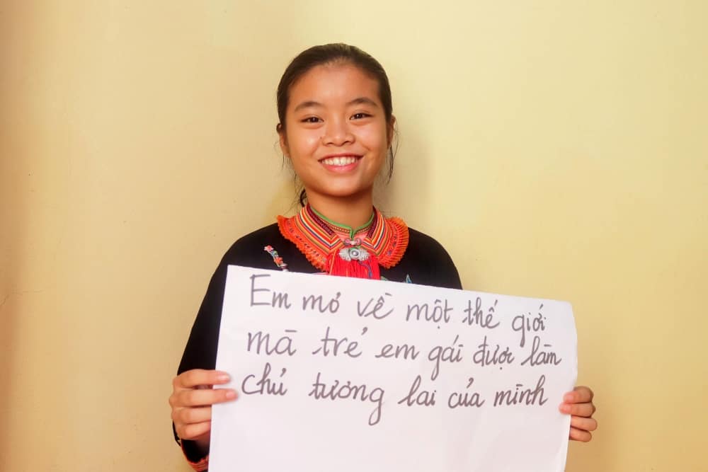 Huyen holds a sign that reads, “I dream of a world where girls are the owners of their futures