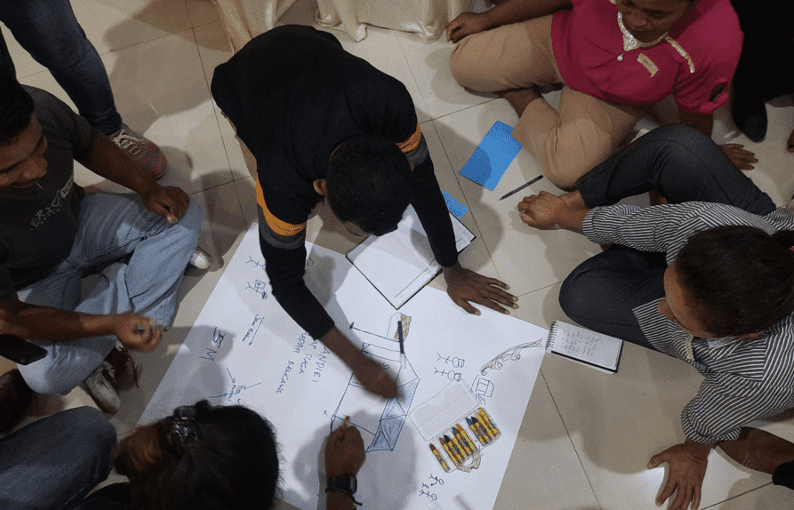 Yoris draws a blueprint at a capacity building activity in Indonesia.