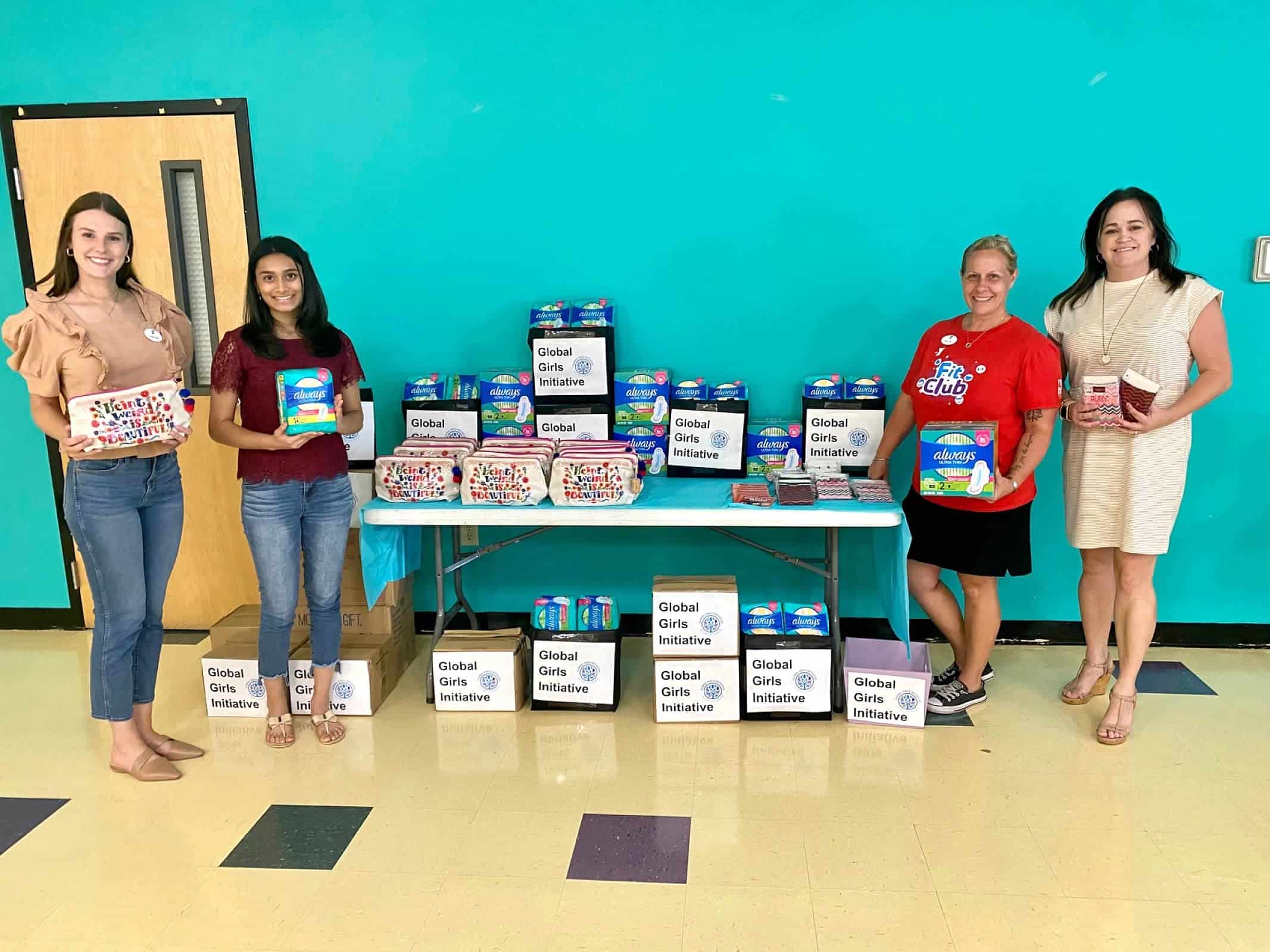 Aanya and other Global Girls Initiative supporters pose with period products to be donated to girls and menstruating people in need.