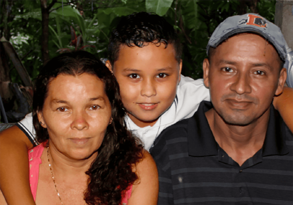 Toñito (center) photographed in El Salvador with his mother and father. [This photo was taken in 2019.]