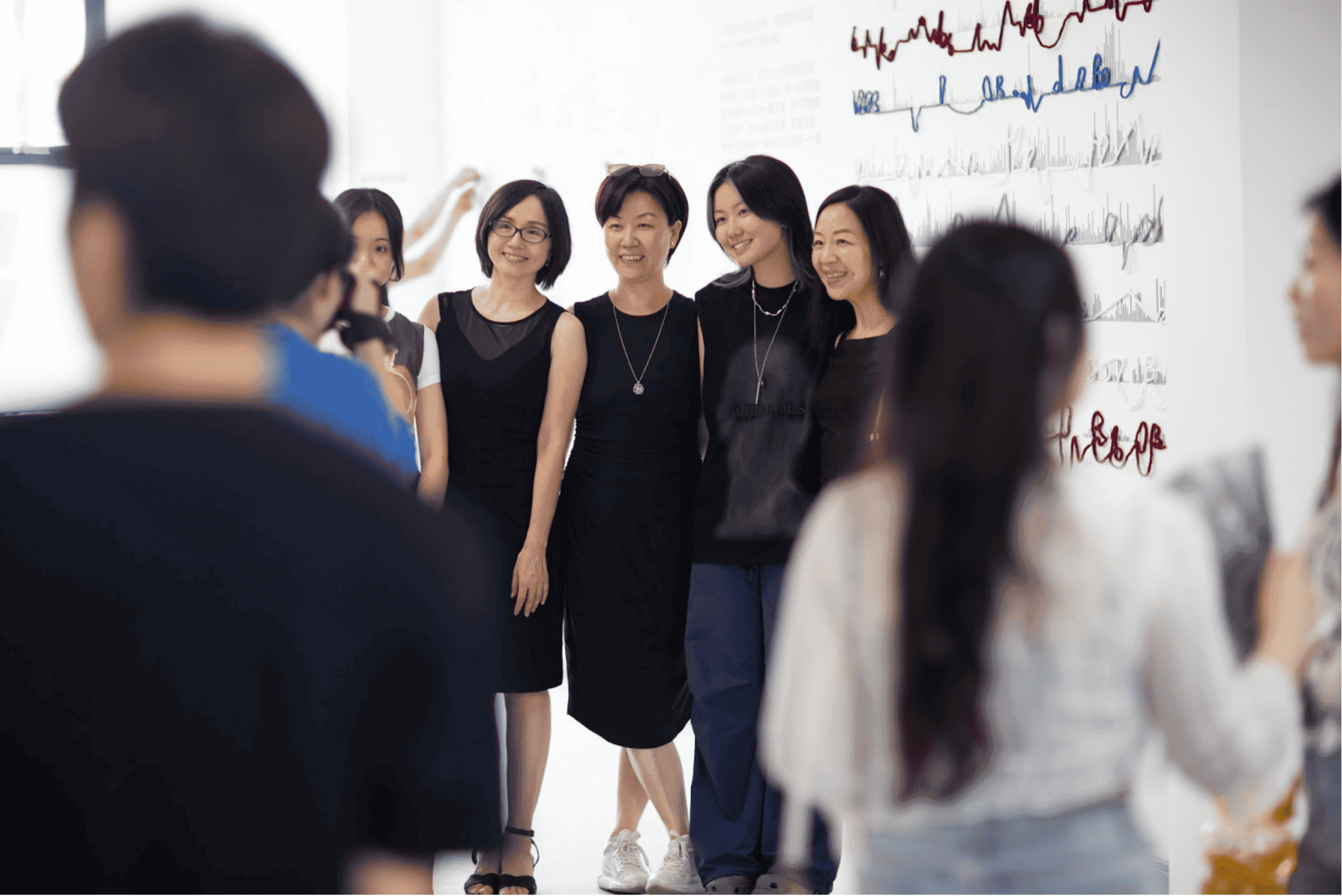 Coco poses for pictures with a group of people at the opening ceremony for her curated exhibition, “A Weaving Mess,” in Shanghai. 