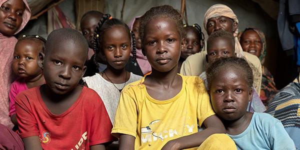 Kids in bright color t-shirts stare at camera
