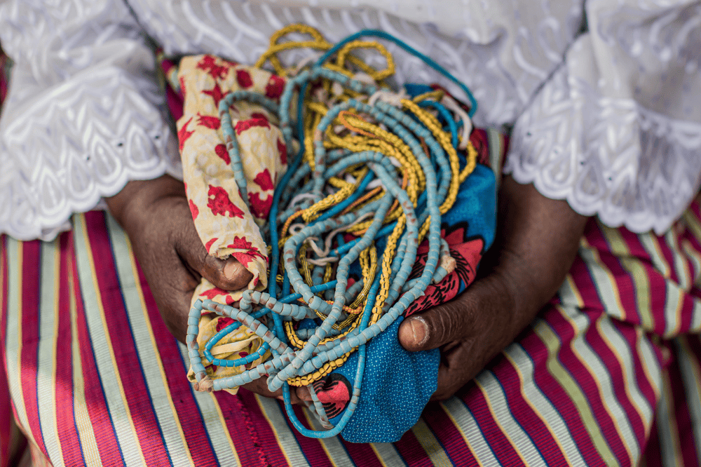 Inna holds several homemade cloth and bead pads in her lap.