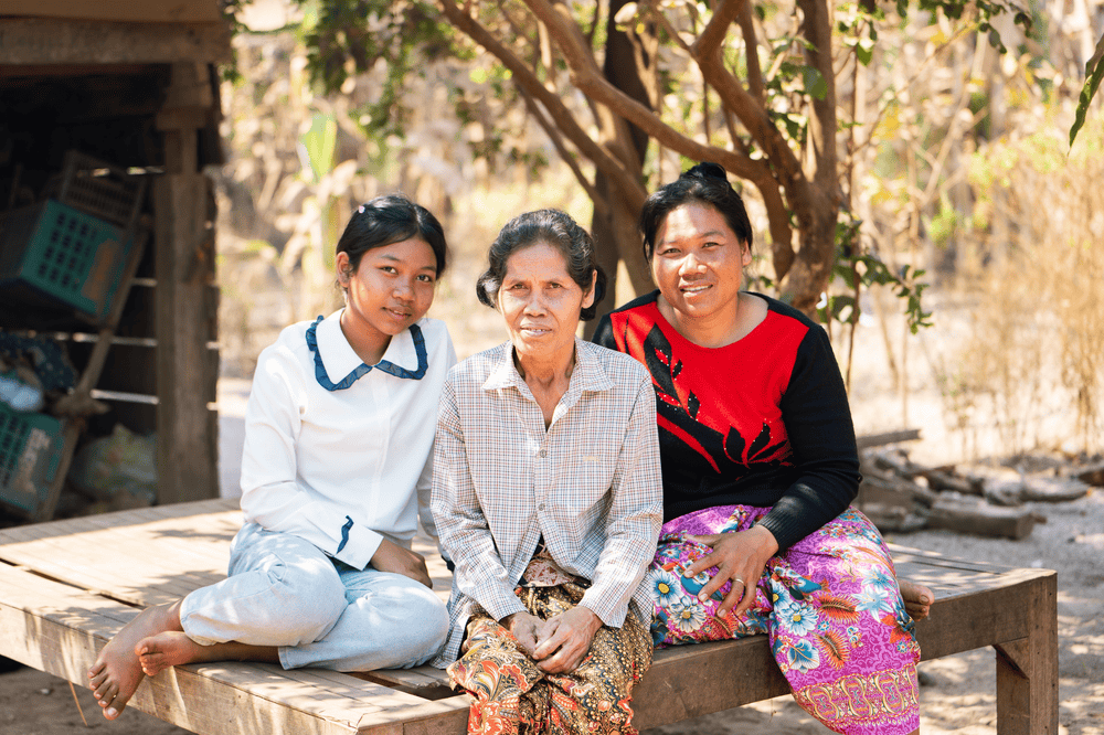 Teenage Seila (left) sits with her grandmother Bui Non (center) and mother Sokna (right).