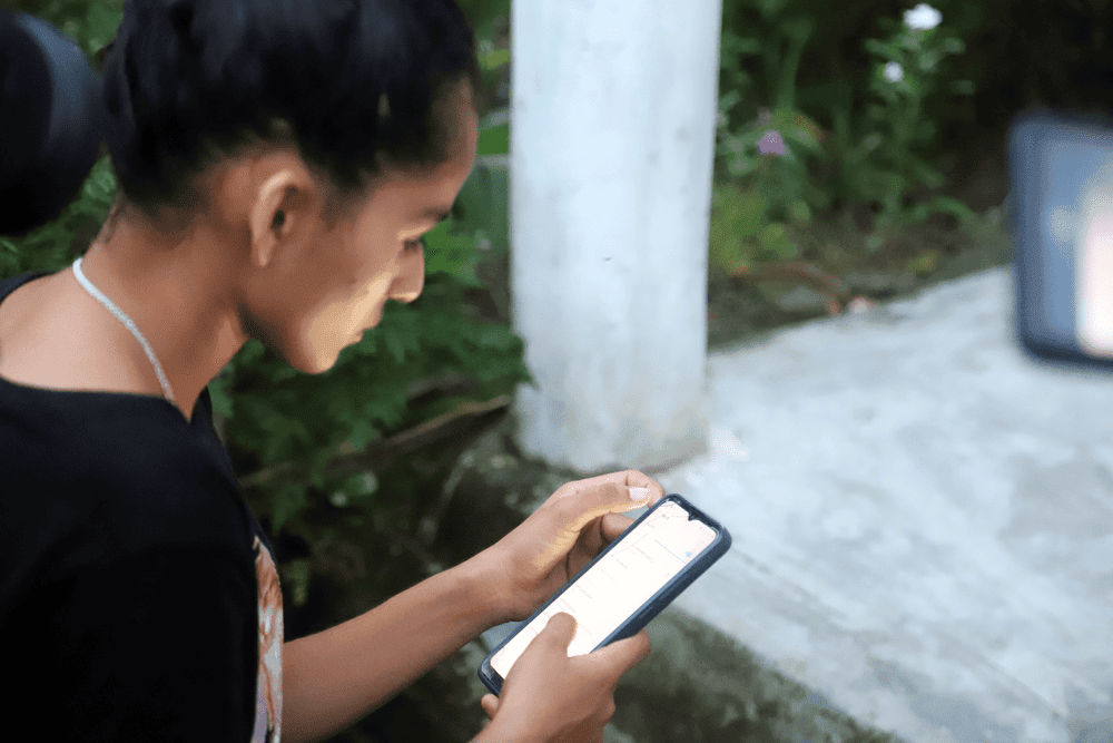 Girl faces away from the camera, looking at phone screen.