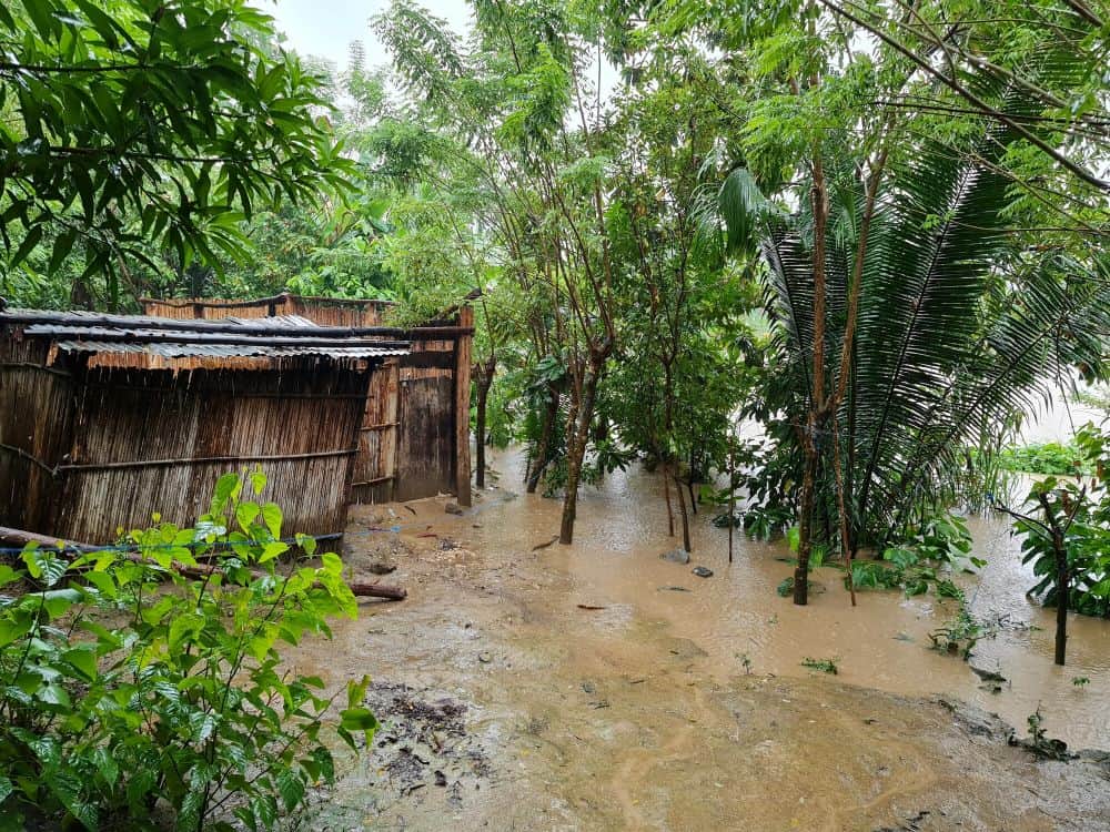Muddy water washes against a home in Guatemala.