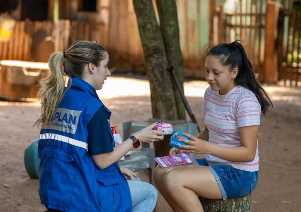 Alma, 16, receives menstrual health kit from Plan staff in Paraguay. 