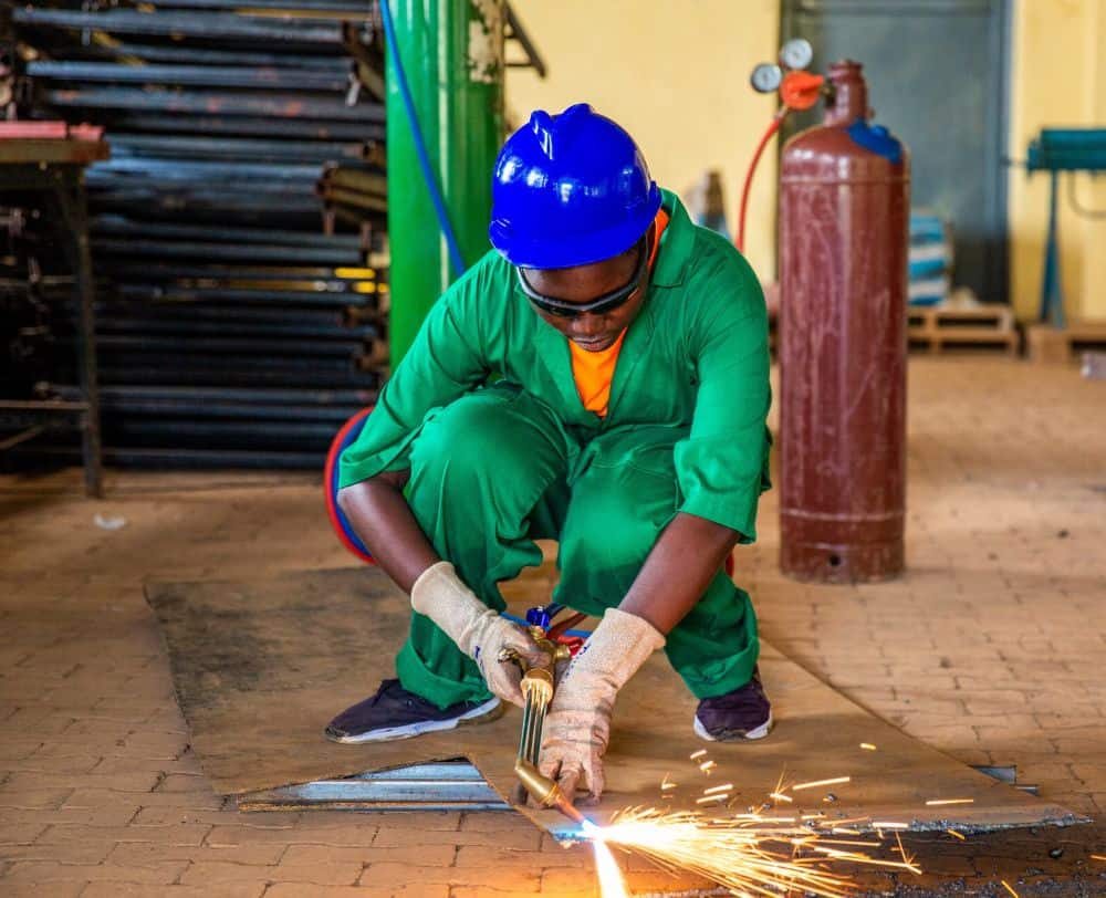 Denyse, 21, is proud to be a welder after participating in Plan’s vocational training program in Rwanda.