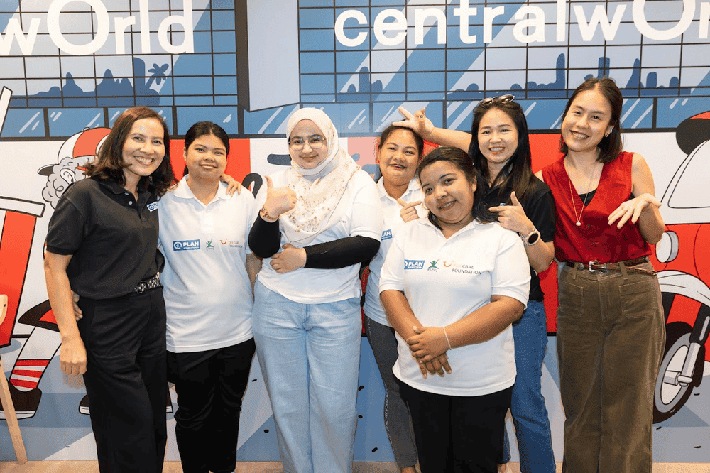A group of women at KFC Thailand stand together, smiling and posing for a picture.