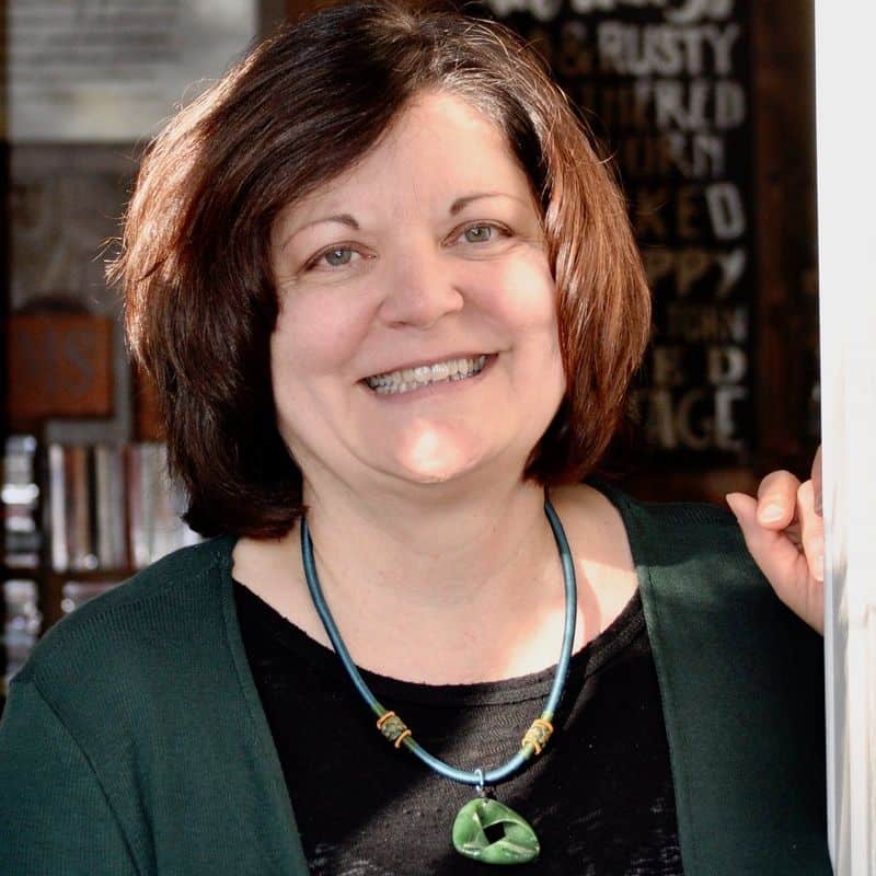 Woman with short brown hair smiles at camera