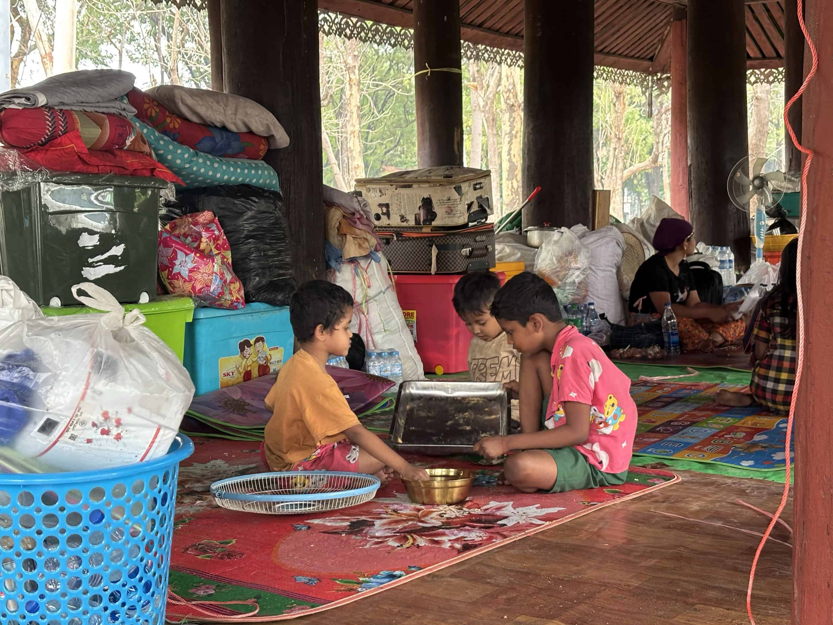 Children share a meal at a temporary shelter set up in a temple after the earthquake in Myanmar.