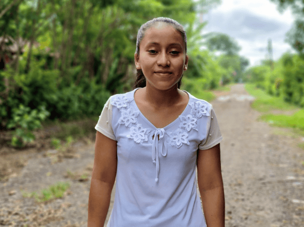 Delia, a 17-year-old peer educator in Guatemala, stands outdoors in her community after receiving menstrual health training through Plan International and Kotex®.