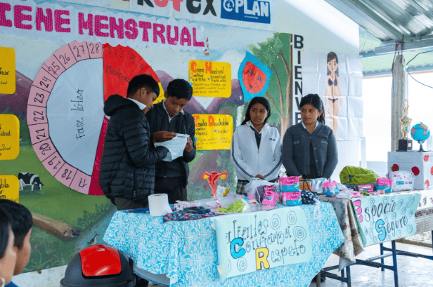 Boys in Guatemala participate in a menstrual health education session, learning how to use pads as part of a Plan International and Kotex® initiative to promote understanding and support across genders.