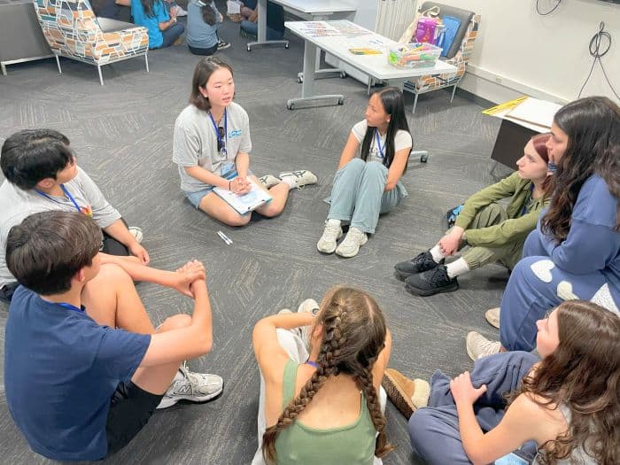Young participants and facilitators in discussion during a Youth Leadership Academy session.