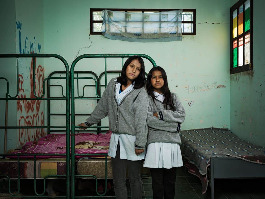 Sisters Carla and Janet stand inside their boarding school dormitory in Bolivia