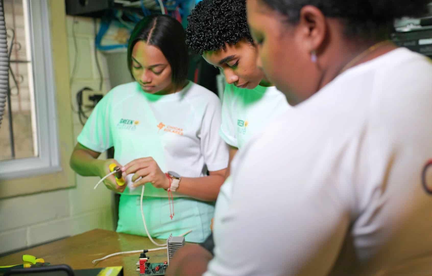 Young women practice electrical wiring during a hands-on Solar Girls training session in the Dominican Republic.